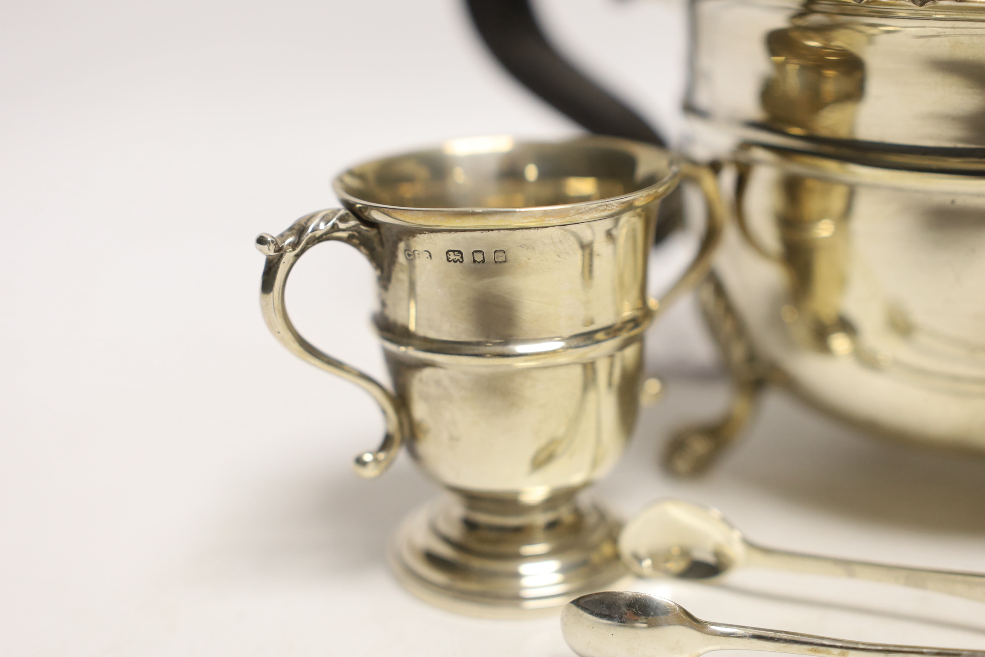 A George V silver teapot, J. Sherwood & Sons, Birmingham, 1913, an Irish silver sugar bowl pair of silver sugar tongs and a small silver two handled trophy cup, gross 18.7oz.
